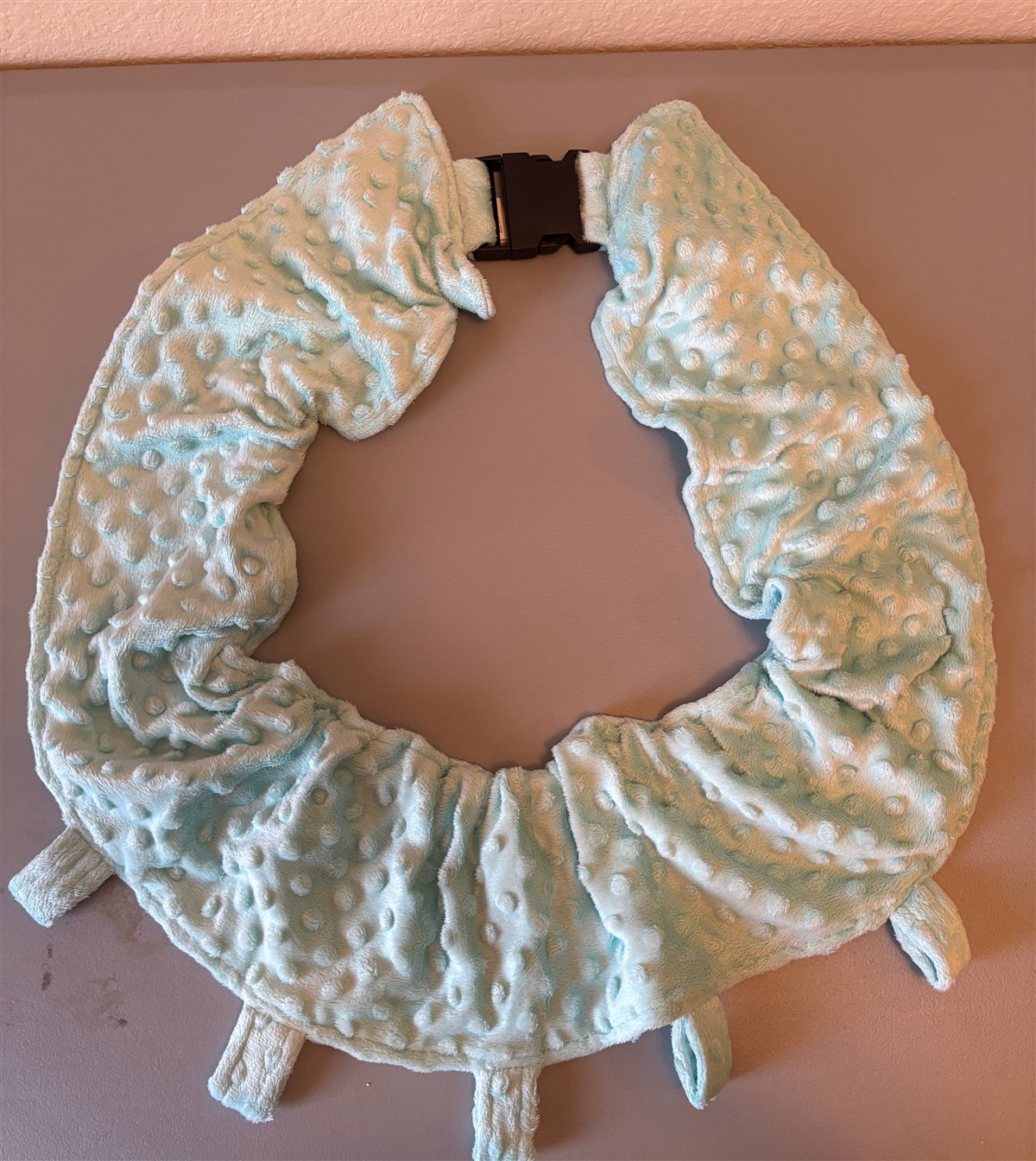 The Clingy Baby Halo — a mint minky neck band with a buckle and sewn attachment loops, laid flat